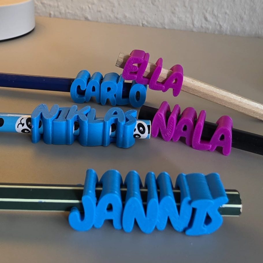 Bunte Namensschilder aus Kunststoff auf einem Tisch angeordnet.