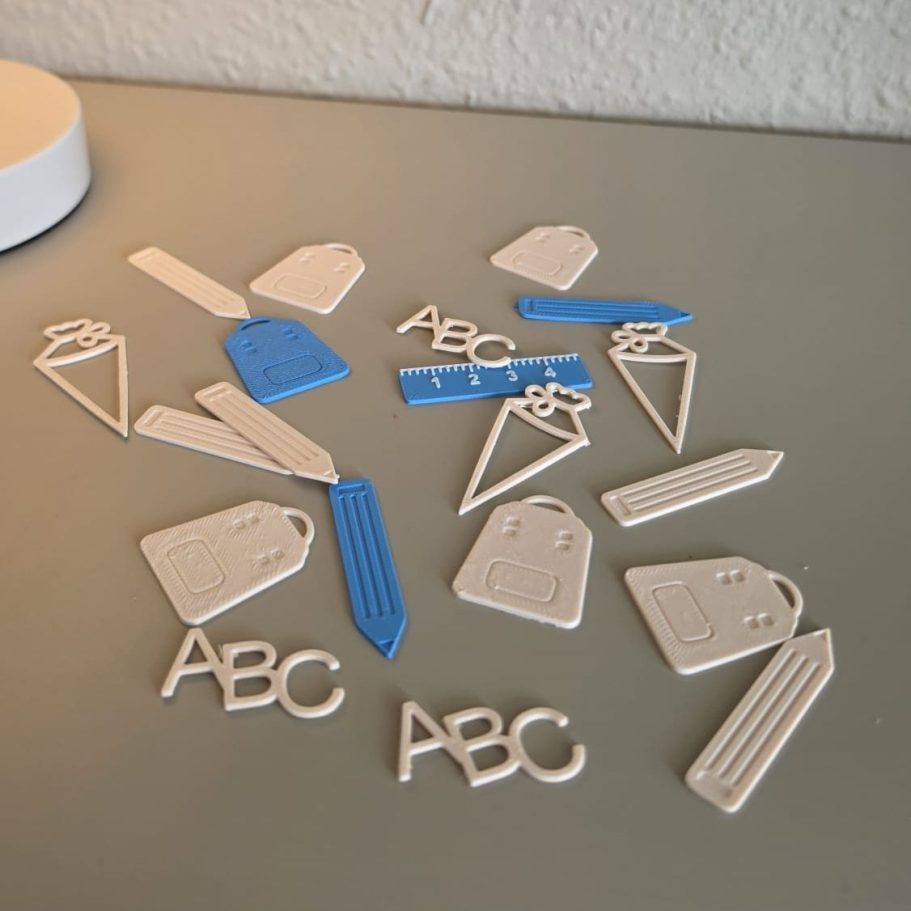 Bunte Kunststoffformen und Buchstaben auf einem Tisch angeordnet.