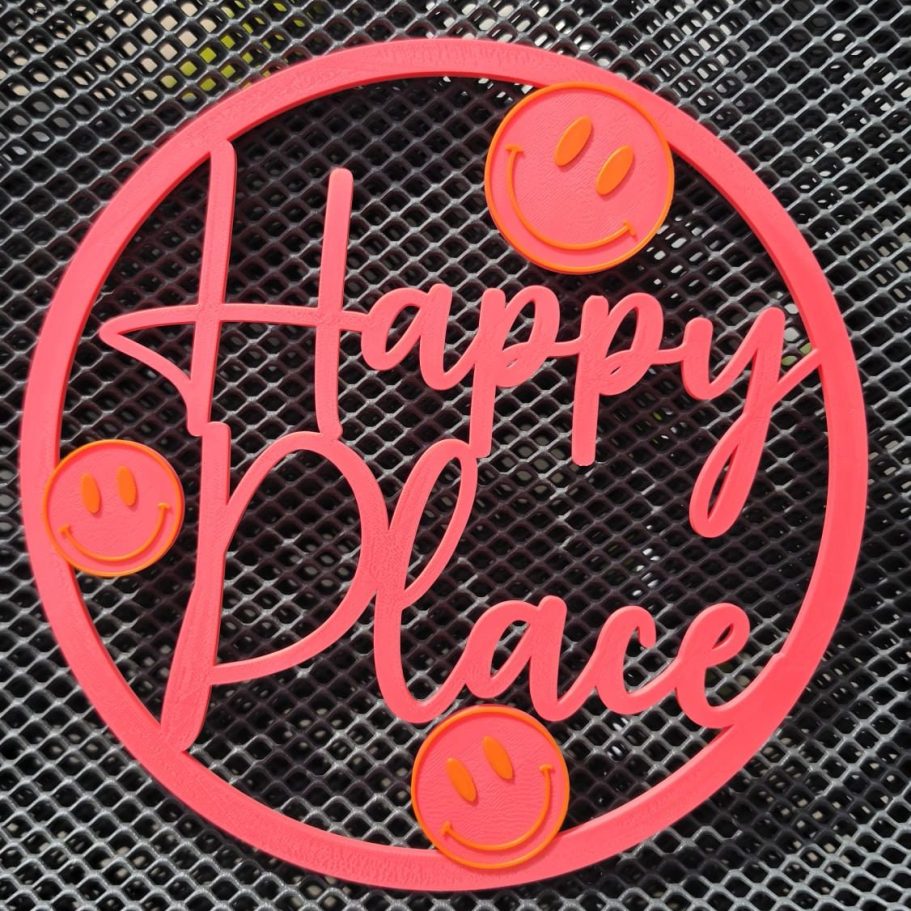 Pinker Schriftzug "Happy Place" mit lächelnden Gesichtern 