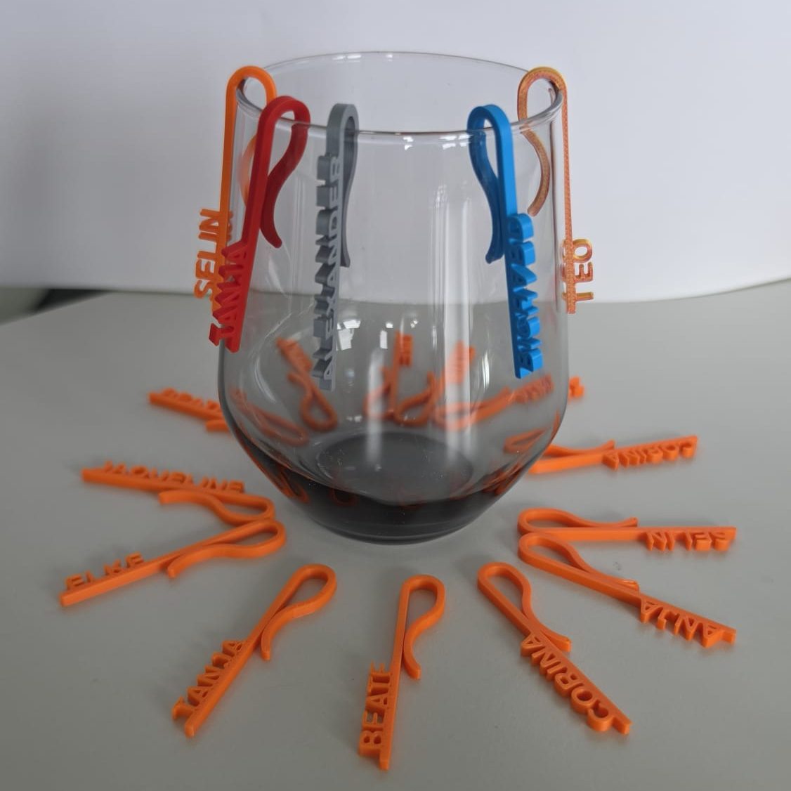 Bunte Glasmarkierer um ein Glas  angeordnet.