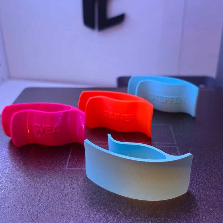 Farbenfrohe Schuhlöffel in Rot, Pink, Orange und Blau auf dem Druckbett eines 3D Druckers