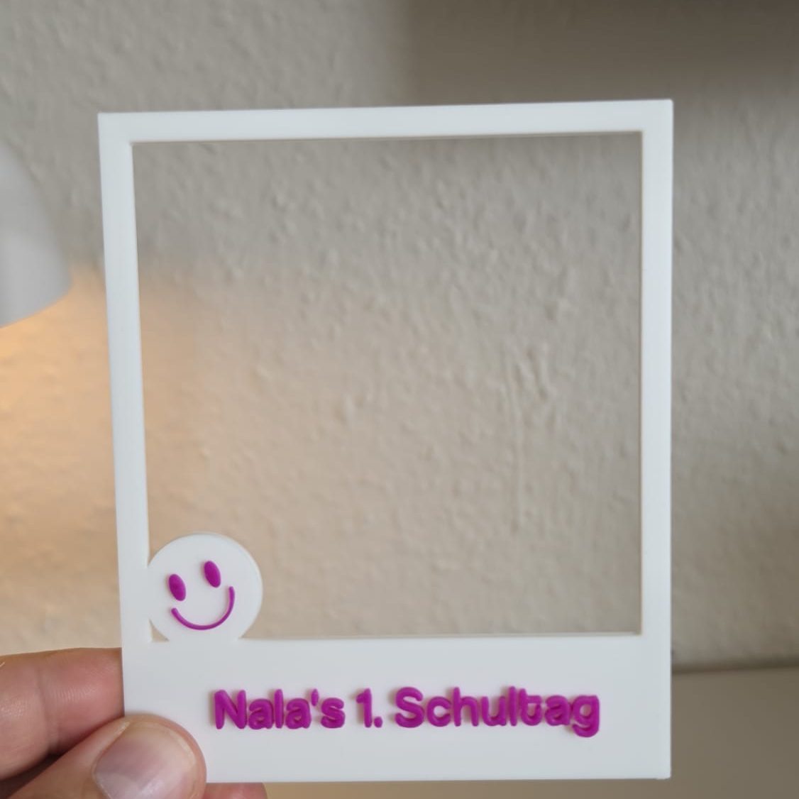 Ein leeres Foto-Rahmen mit der Aufschrift "Nala's 1. Schultag" und einem Smiley.