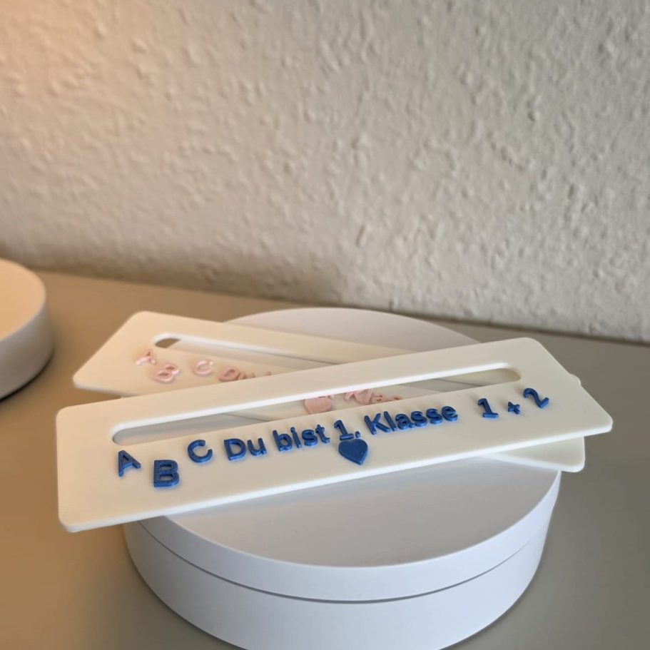 Zwei Schablonen mit Buchstaben und der Aufschrift "Du bist in Klasse 1".